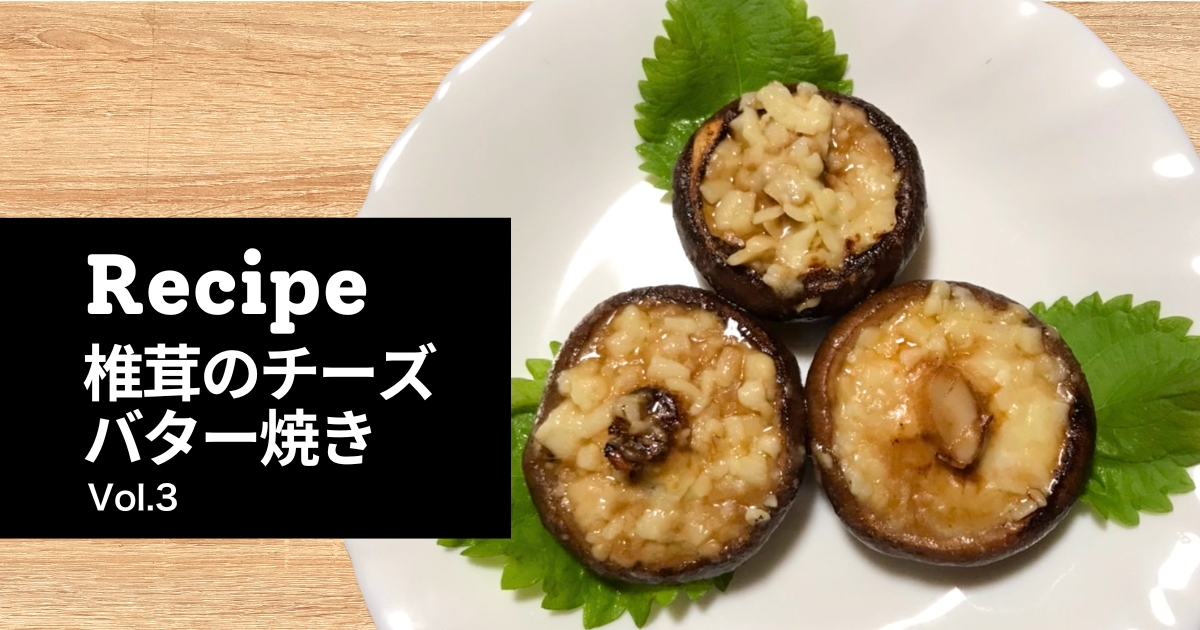 白い皿に盛りつけられた椎茸のチーズバター焼き。傘の内側にチーズがとろけ、艶やかに焼き上がった椎茸が3つ並んでいる。とらいあんぐる農園のレシピシリーズVol.3。